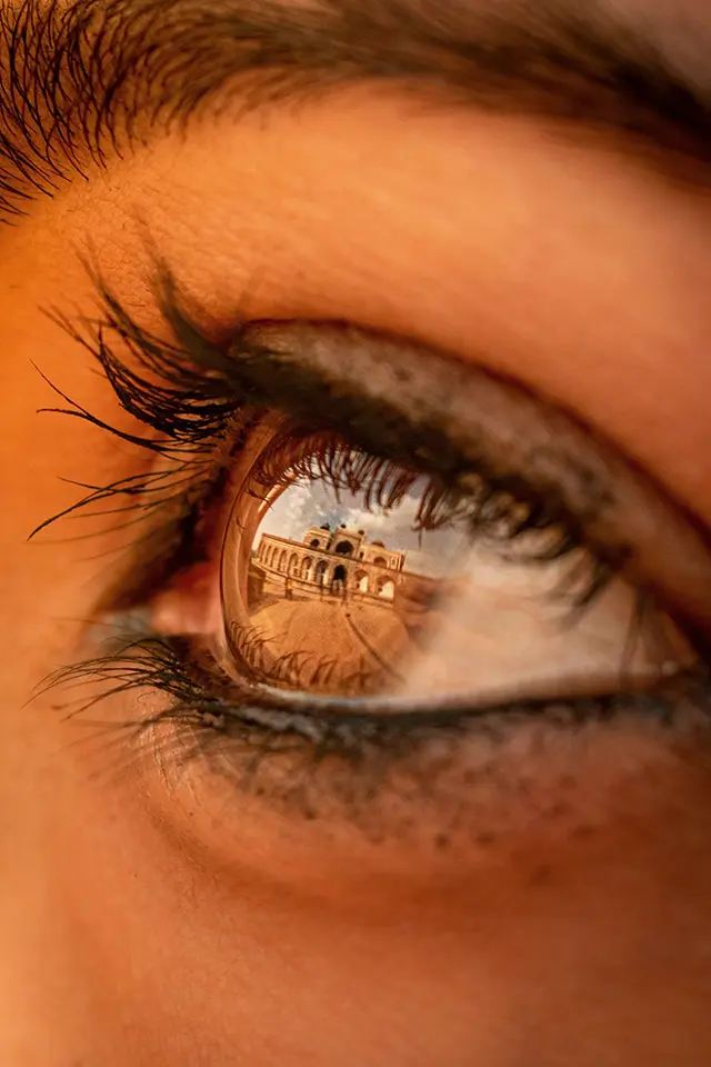A hypnotised eye, reflecting a historical building in the distance.